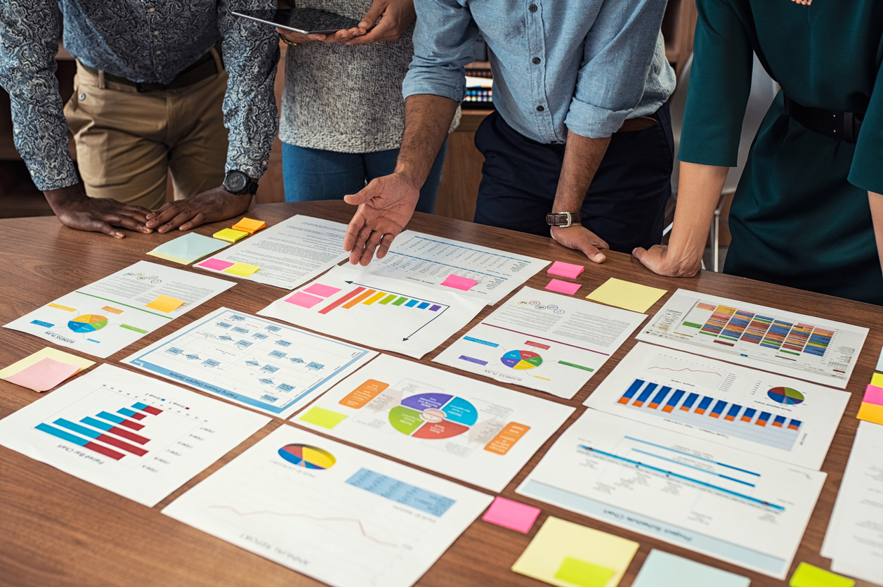 Business casual team working on graphs The Value of Cultural Assessments | Employees looking at data charts