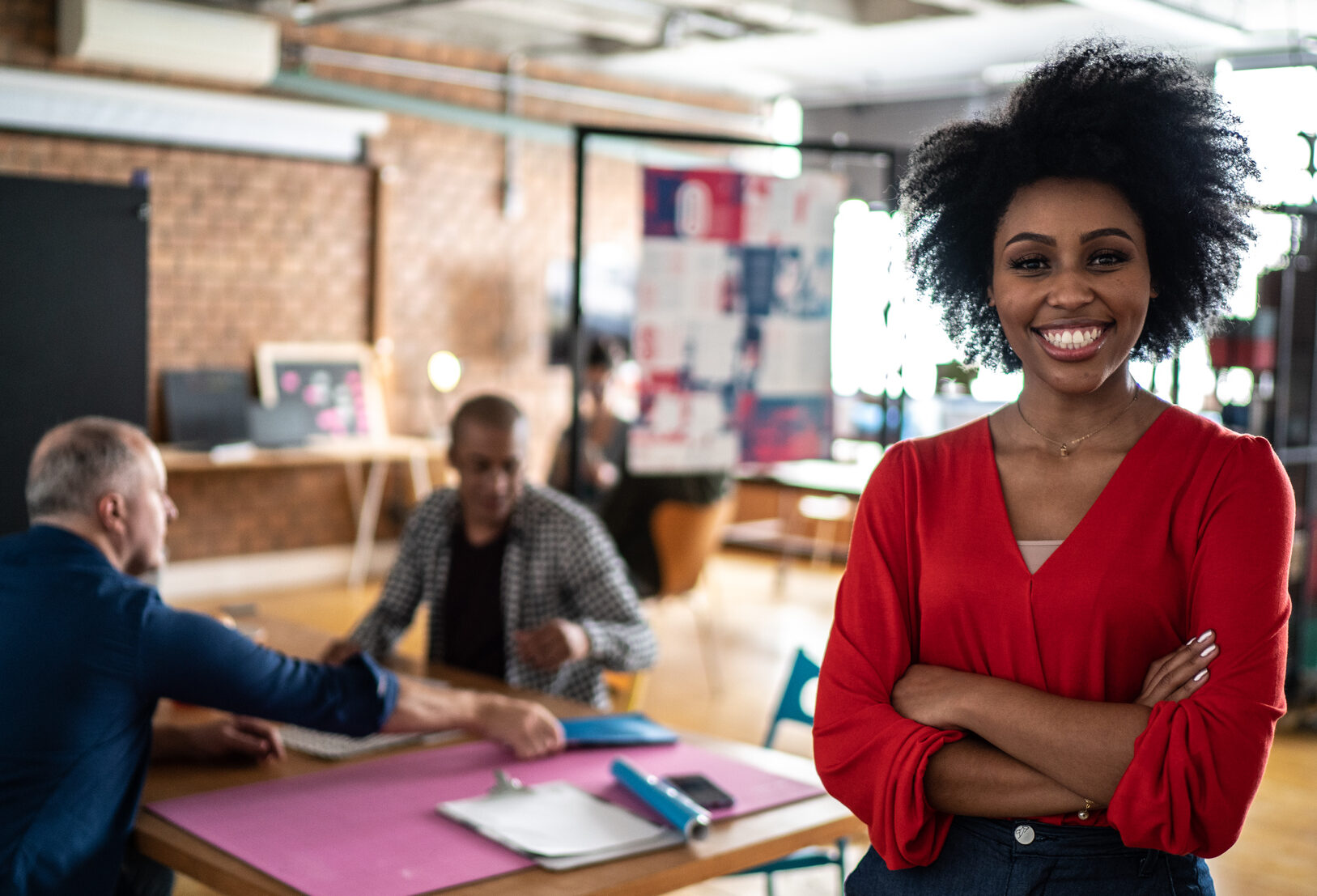 A Spectra Partner smiles in a busy, diverse office